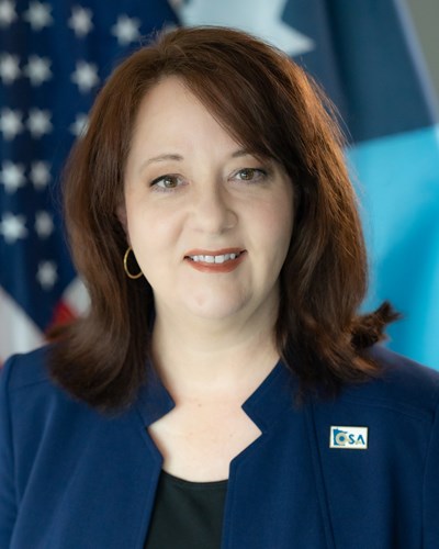 Official headshot of Auditor Julie Blaha with American and Minnesota flag in background